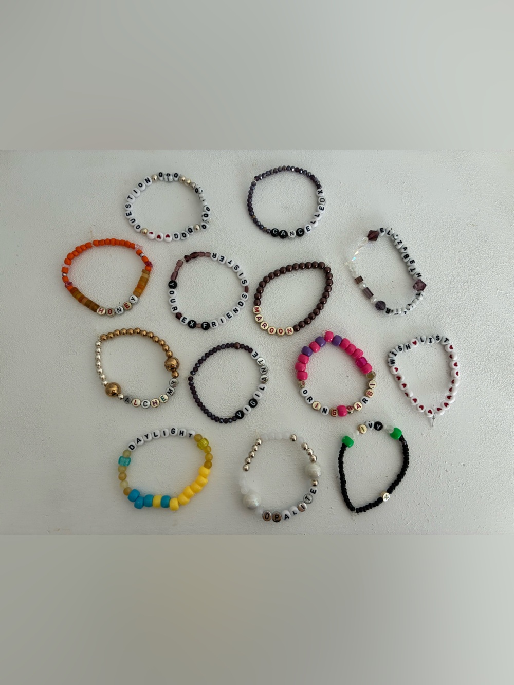 13 Swiftie friendship bracelets - homemade - various - on Stretch Magic bands